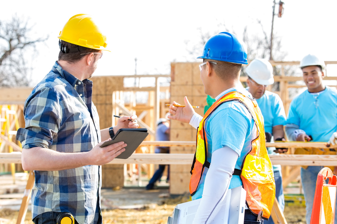 Construction foreman and manager discuss new home under construction